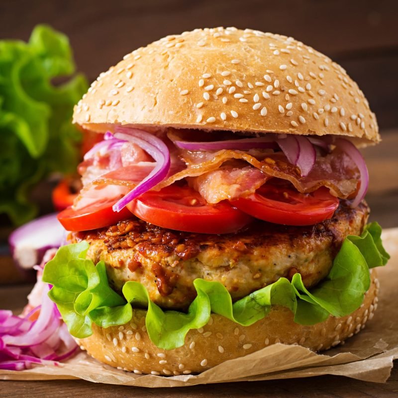 Big sandwich - hamburger burger with beef, red onion, tomato and fried bacon.